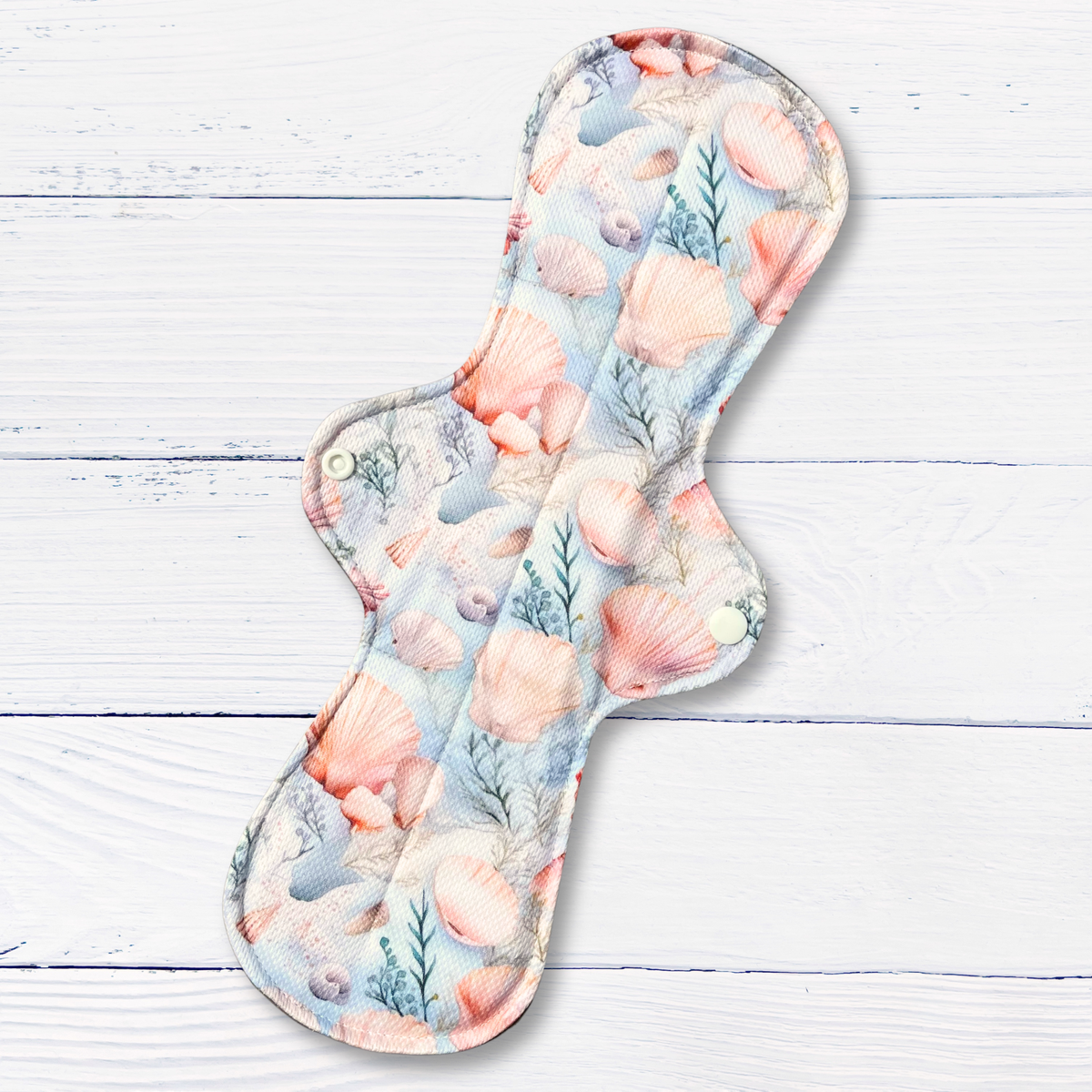 Seashell patterned cloth pad on a wooden surface