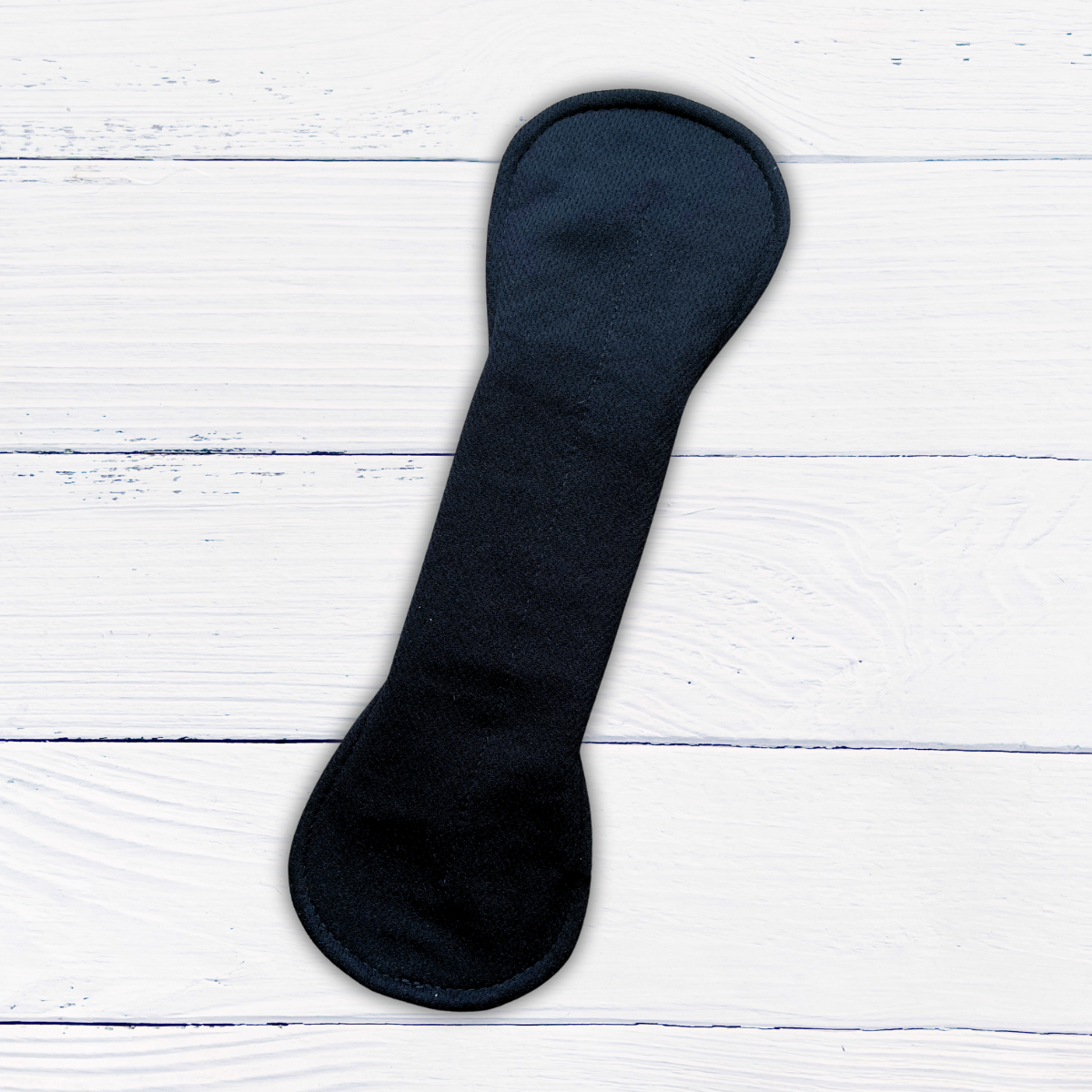 amie active black long reusable pad snapped on a rustic white wood background