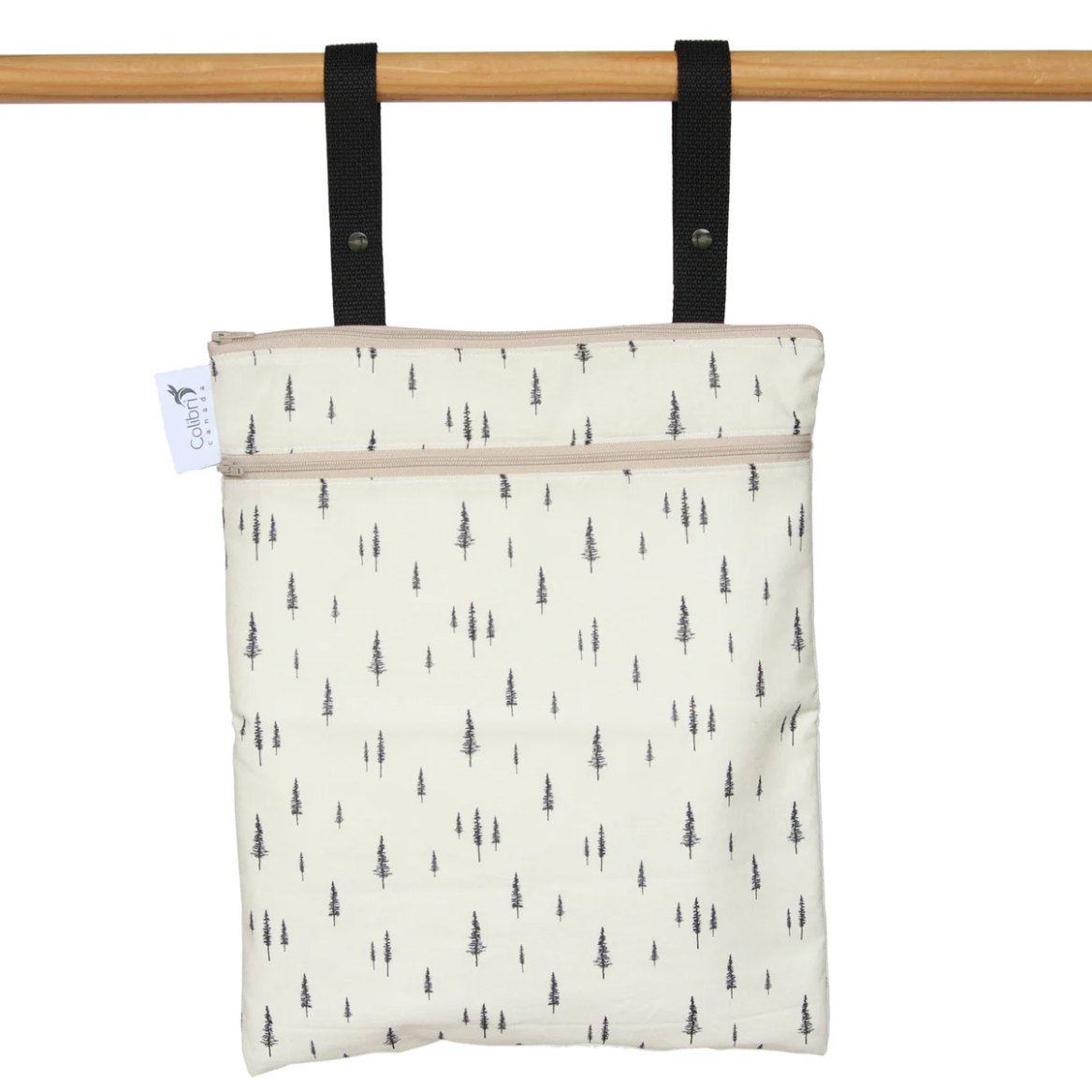Patterned bag with black straps hanging on a wooden rod against a white background