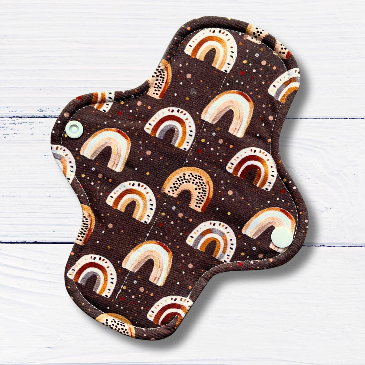 Fabric pad with rainbow pattern on a wooden surface