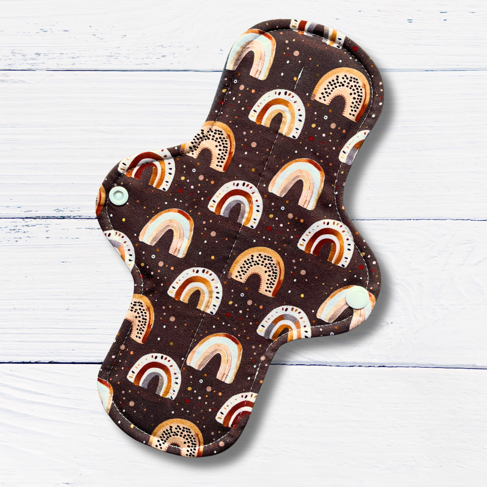 Earthy rainbow patterned cloth pad on a wooden surface