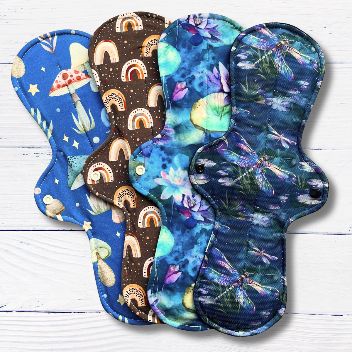 Set of colourful cloth pads with various patterns on a white wooden surface