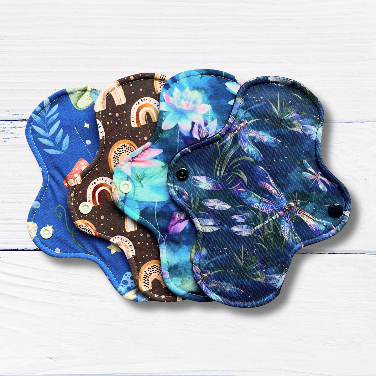 Set of colorful cloth pads on a white wooden surface