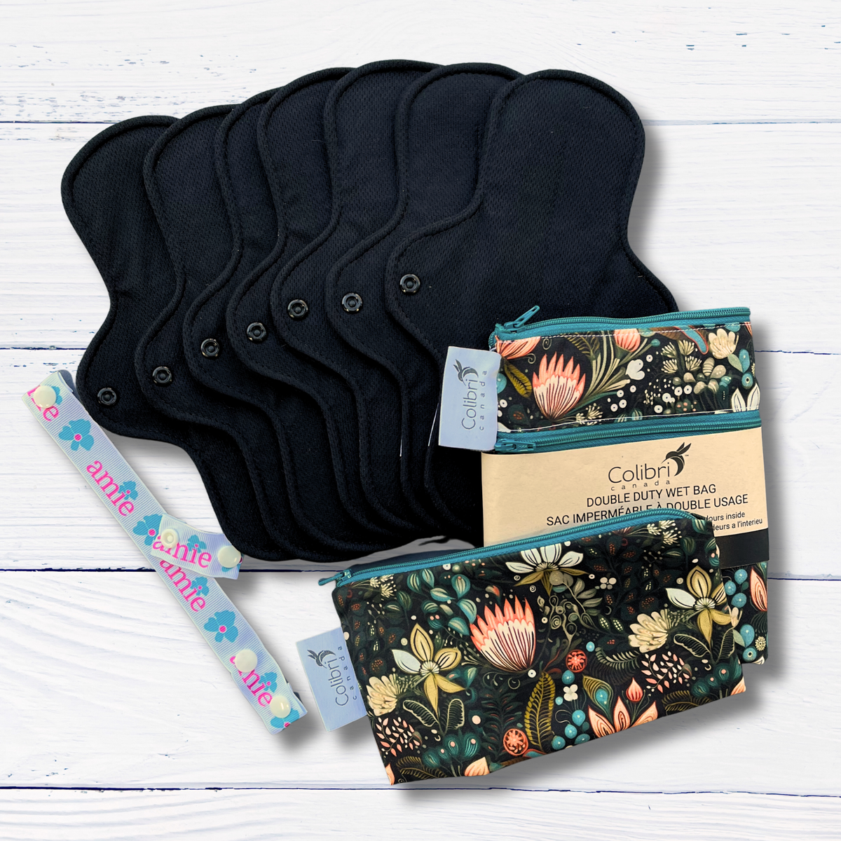 Black reusable pads and floral-patterned bags on a white wooden surface