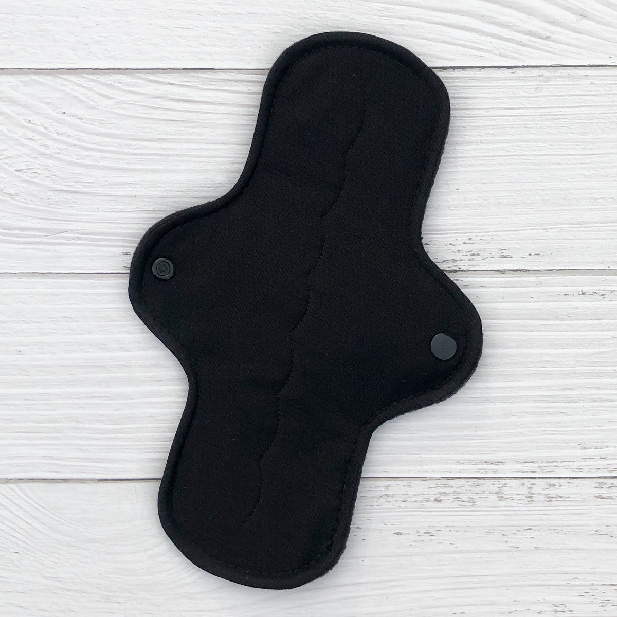 amie reusable pad in moderate absorbency topped with black athletic wicking jersey