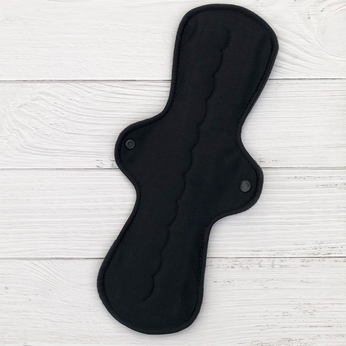 amie reusable pad in heavy absorbency topped with black athletic wicking jersey